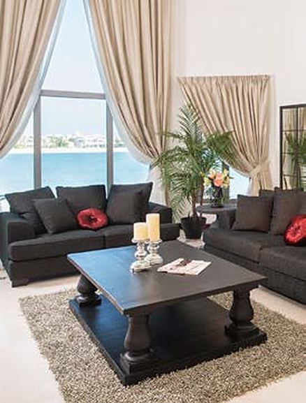 Living room with sea views and dark sofas