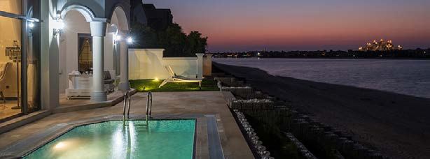 Villa pool terrace looking out over the water at sunset